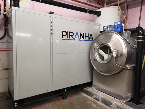 Laundry facility utilizing ground-source heat pumps with waste water